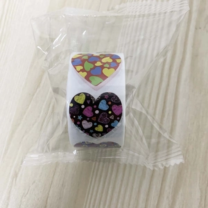 Detail view of heart-shaped stickers on a roll with colorful patterns in plastic wrap