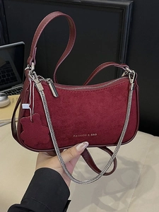 Chic burgundy suede underarm bag with silver chain and cute bear charm in 45-degree view