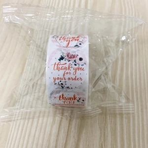 Detail of pink floral Thank You roll stickers in protective packaging for business parcels