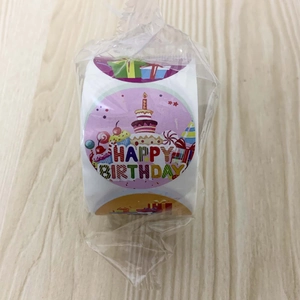 Gros plan d'un rouleau d'autocollants ronds Happy Birthday avec motifs de cupcakes