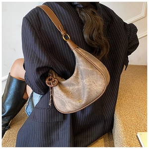 Sac hobo vintage marron avec breloque bretzel et bandoulière réglable sur modèle