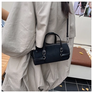 Detail view of the black cylinder shoulder bag with silver hardware and textured PU leather