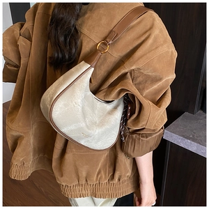 Détail du sac hobo avec texture cuir vintage, bords marrons et détails dorés