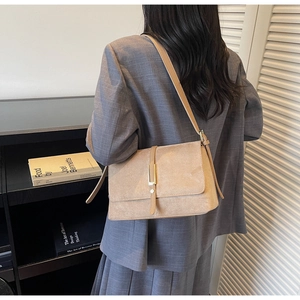 Detail of khaki faux suede shoulder bag with gold buckle and adjustable strap