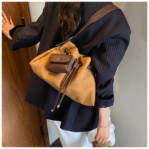 Close-up of a camel suede drawstring bag with a small matching leather charm attached