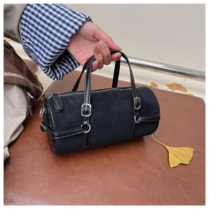 Minimalist black cylinder bag with silver metal buckles and hand straps for autumn look