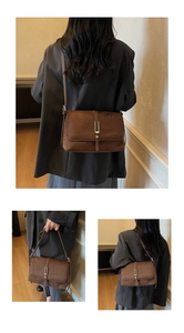 Detail of brown suede crossbody bag showing the metallic bar clasp and textured finish