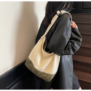 Détail d'un grand sac en toile avec bandoulière noire réglable en beige et vert olive