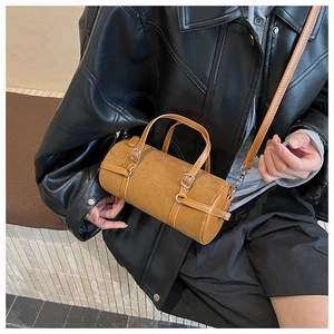 Detail of a brown cylindrical shoulder bag in suede with smooth faux leather trim