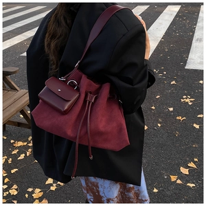 Detail of burgundy bucket bag with drawstring closure and matching small coin purse pendant
