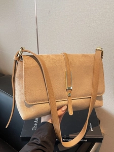 Minimalist brown suede crossbody bag with elegant gold metal buckle and leather strap