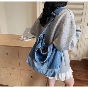Sac hobo spacieux en denim bleu délavé avec bandoulière noire réglable sur l'épaule