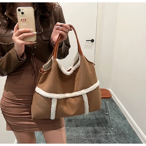 Detailed view of the brown suede tote bag featuring soft white faux shearling trim accents
