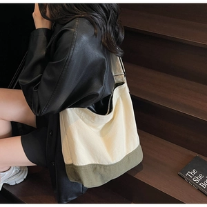 Détail d'un sac fourre-tout en toile avec fond vert olive sur des marches en bois en décor