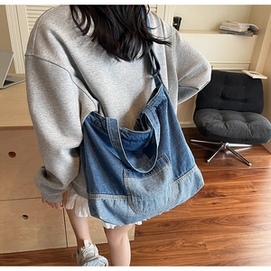 Gros plan d'un grand sac fourre-tout en jean avec design patchwork et poche plaquée