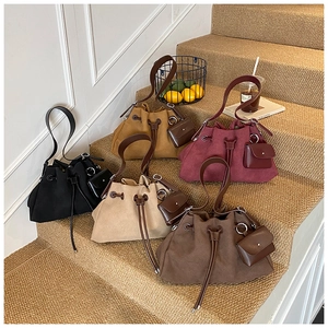 Detail of canvas drawstring bucket bags with leather trim and mini pouches in five colors