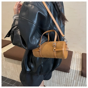 Retro brown cylinder handbag with matte leather texture and silver buckle shown by model
