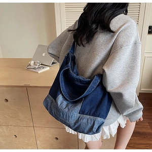 Vue détaillée du grand sac cabas en jean patchwork porté par un modèle en style décontracté