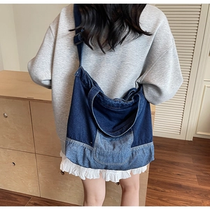Gros plan du sac en denim patchwork avec bandoulière réglable et coutures contrastées