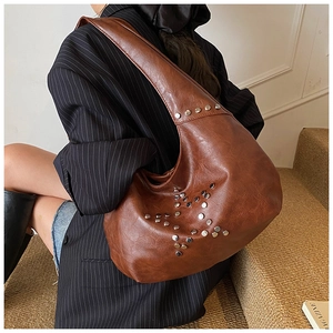 Close-up of brown vintage hobo bag with silver star-shaped rivet details and pebbled texture