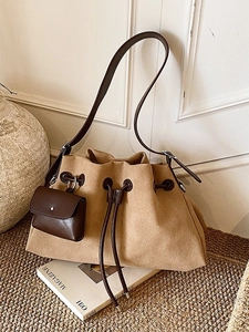 Camel suede hobo bag with dark brown leather straps and mini pouch in a lifestyle setting
