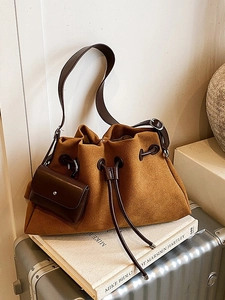 Caramel suede cloud bucket bag with adjustable strap and mini pouch on silver luggage