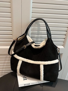 Large black suede tote bag with white shearling trim and adjustable shoulder strap