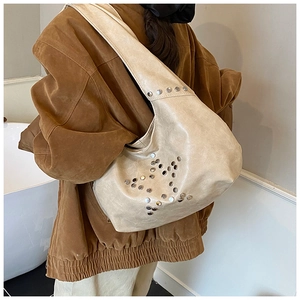 Detail of beige faux leather shoulder bag with silver rivet star pattern on the back