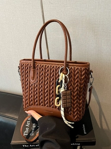 Deep brown V-quilted bucket bag with cute chocolate pendant and adjustable shoulder strap