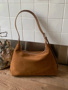 Brown suede underarm shoulder bag with adjustable leather strap and silver zipper closure