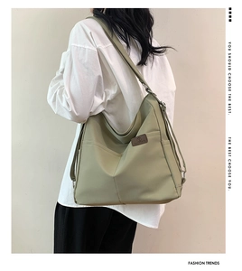 Detail view of khaki waterproof nylon hobo bag featuring side pocket and leather logo tag