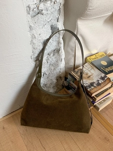 Minimalist retro dark brown suede hobo shoulder bag with leather strap on white wall