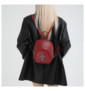 Sac à dos rouge en cuir avec rivets et croix porté par un mannequin en veste de cuir noir