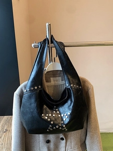 Vintage black rivet hobo bag with silver star pattern decoration on a shoulder bag