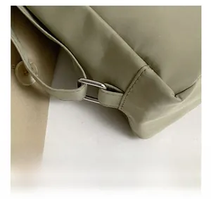 Close-up of premium silver metal hardware on a light green waterproof nylon backpack