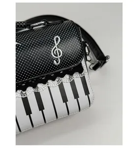 Detail of piano theme shoulder bag showing embroidery and black lace trim accents