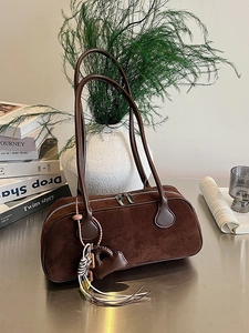 Retro dark brown suede baguette bag with heart charm shown in a cozy lifestyle setting