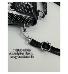 Detail of adjustable and detachable shoulder strap with silver metal hooks on polka dot bag