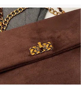 Detail of vintage brown suede shoulder bag featuring a golden woven metal buckle lock