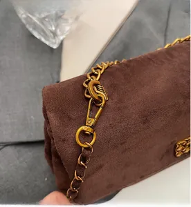 Detail of durable vintage gold metal hook and thick chain on brown suede bag