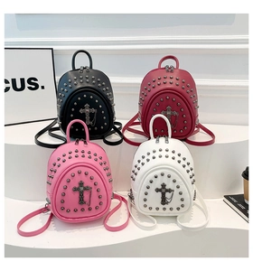 Gros plan de mini sacs à dos punk avec clous métalliques et détail de pendentif croix