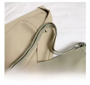 Detail showing the comfortable double straps of the green nylon backpack with metal buckles