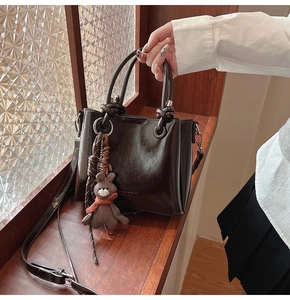 Dettaglio della borsa tote in ecopelle marrone scuro con ciondolo a coniglio