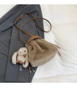 Sac seau en fausse fourrure de lapin marron avec breloque lapin sur une veste de costume