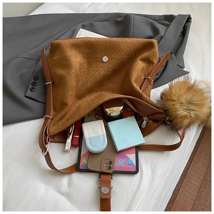 Détail de l'intérieur du sac cabas tressé marron avec fermoir magnétique et pompon décoratif