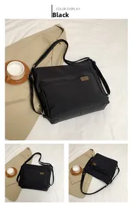 Detail view of black waterproof nylon bag with adjustable strap and leather logo patch