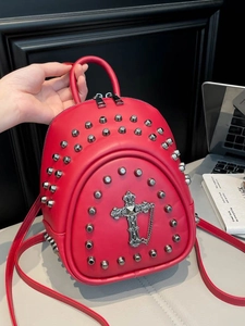 Mini sac à dos gothique rouge avec rivets et croix sur fond de bureau moderne