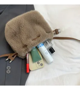 Détail d'un sac seau en peluche marron montrant sa capacité pour le maquillage