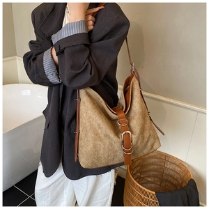 Detail of vintage suede hobo tote bag with brown leather straps and metallic buckle hardware
