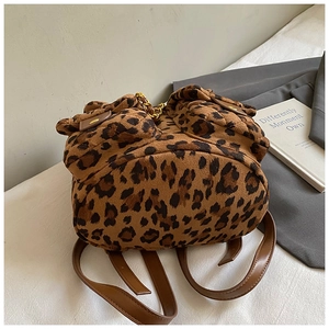Detail eines Rucksacks mit Leopardenmuster, zwei Fronttaschen und Kettenriemen